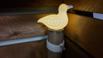 Weiße Keramik Möwe auf Holzpoller mit Licht
